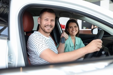Photo of Happy family with keys inside new car