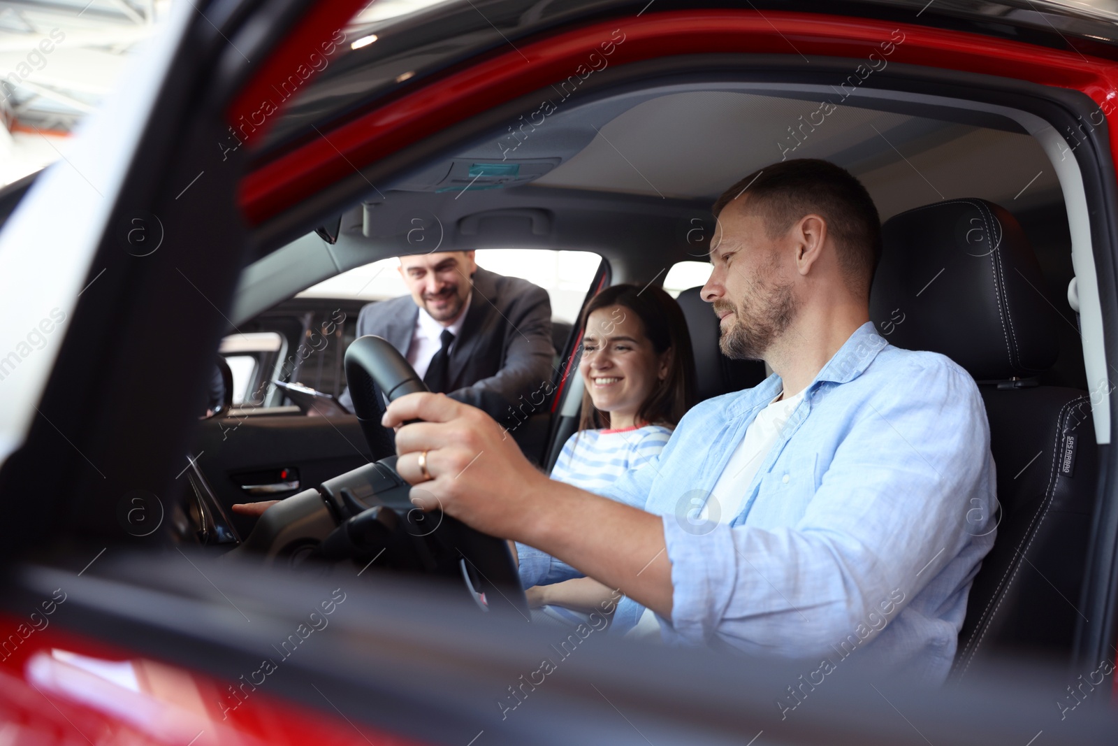 Photo of Salesman showing new car to happy family, selective focus