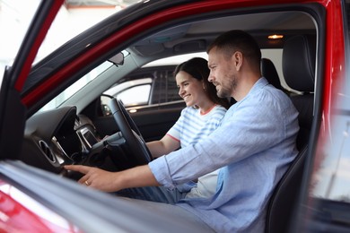 Photo of Happy family sitting inside new car. Luxury vehicle