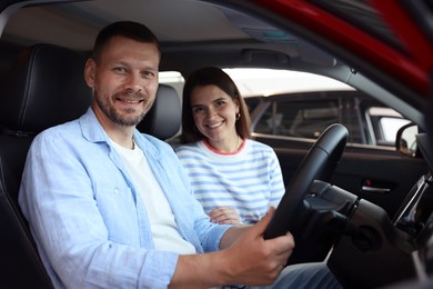 Photo of Happy family sitting inside new car. Luxury vehicle