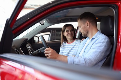 Photo of Happy family sitting inside new car. Luxury vehicle