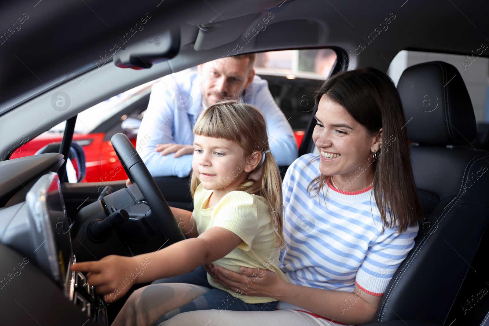 Happy family sitting inside new car. Luxury vehicle Photo of Happy family sitting inside new car. Luxury vehicle