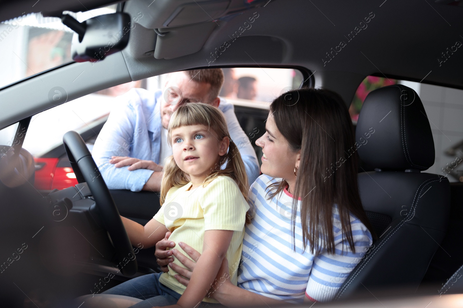 Happy family sitting inside new car. Luxury vehicle Photo of Happy family sitting inside new car. Luxury vehicle