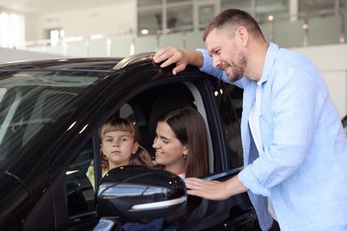 Photo of Happy family and new car in salon