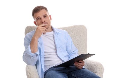 Photo of Thoughtful psychologist with clipboard sitting on armchair against white background