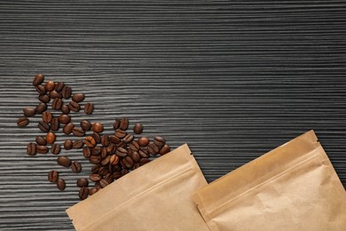 Photo of Zipper stand-up pouches and coffee beans on black textured table, flat lay. Space for text
