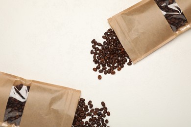 Photo of Zipper stand-up pouches and coffee beans on white table, flat lay. Mockup for design