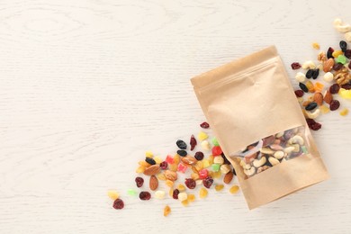 Photo of Zipper stand-up pouch with dried fruits and nuts on white wooden table, flat lay. Mockup for design