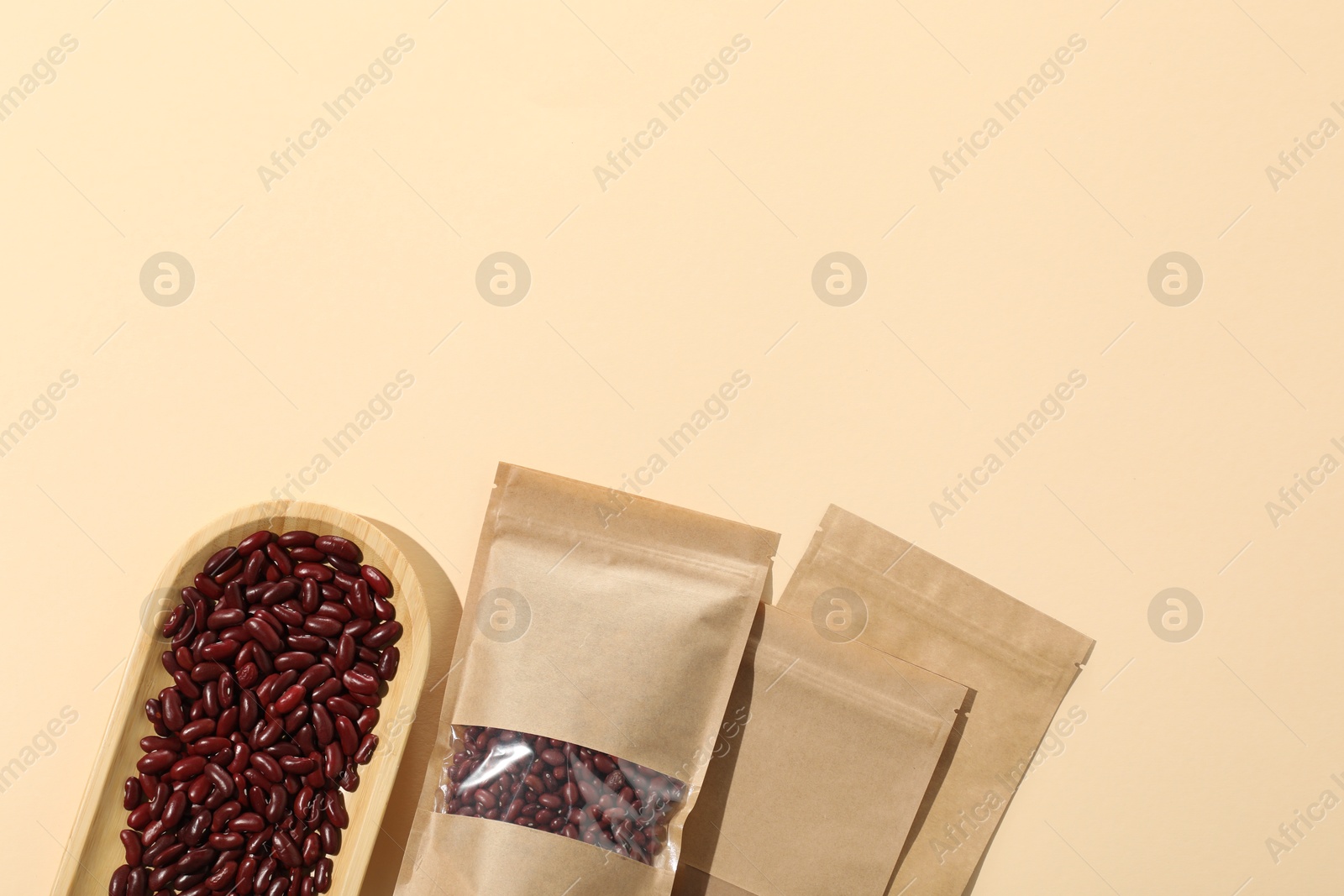 Zipper stand-up pouches and dry kidney beans on beige background, flat lay. Mockup for design Photo of Zipper stand-up pouches and dry kidney beans on beige background, flat lay. Mockup for design