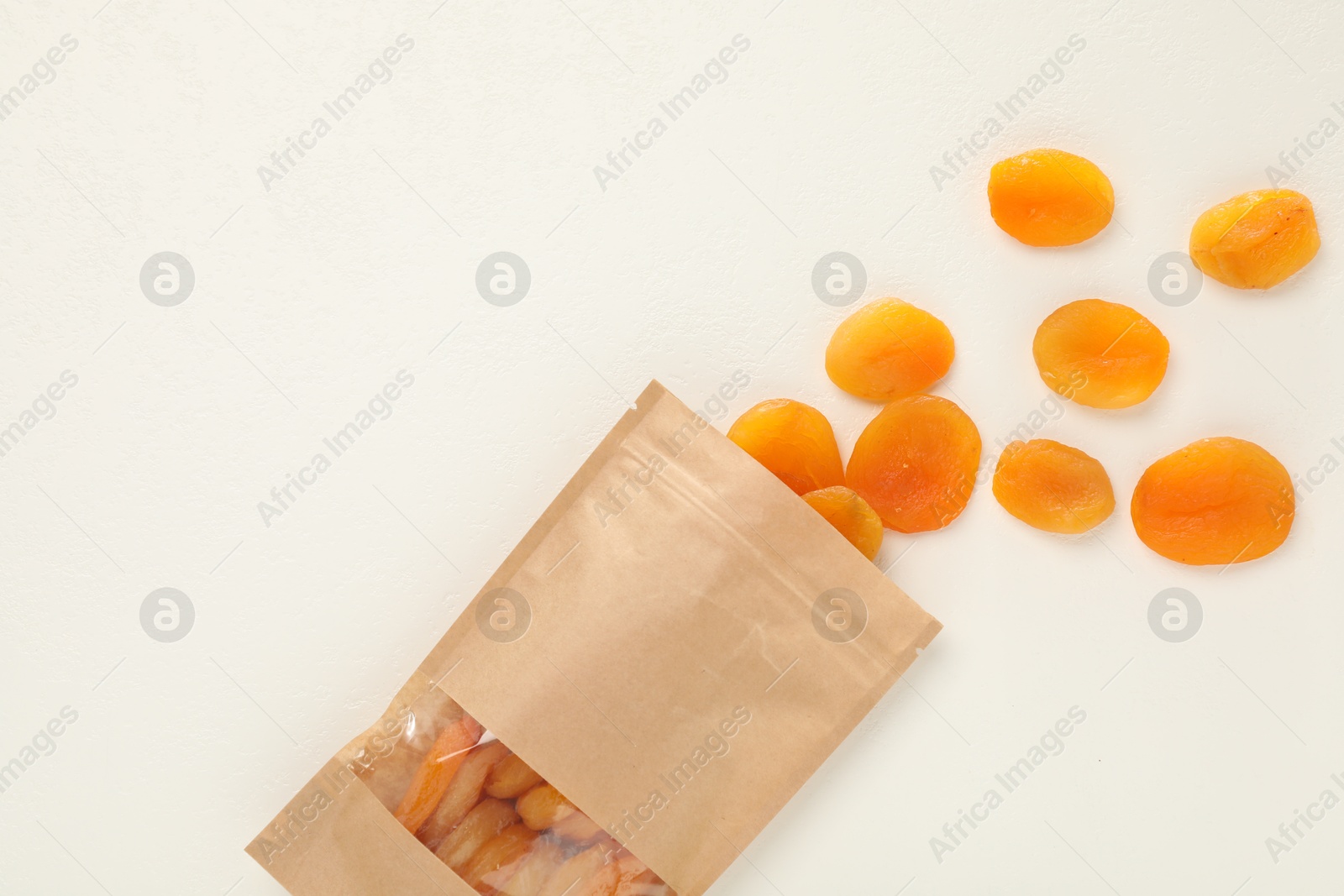 Zipper stand-up pouch with dried apricots on white table, flat lay. Mockup for design Photo of Zipper stand-up pouch with dried apricots on white table, flat lay. Mockup for design