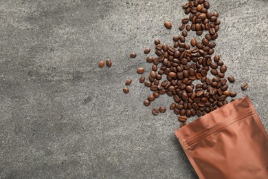 Photo of Zipper stand-up pouch and coffee beans on grey table, flat lay. Space for text