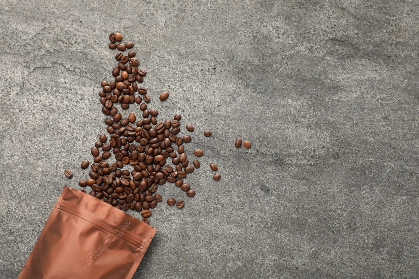 Zipper stand-up pouch and coffee beans on grey table, flat lay. Space for text Photo of Zipper stand-up pouch and coffee beans on grey table, flat lay. Space for text