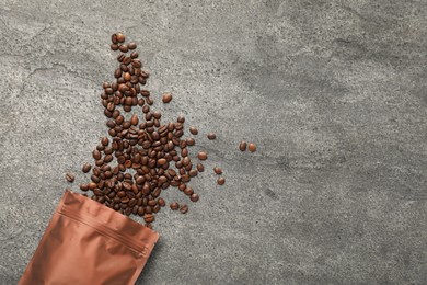 Photo of Zipper stand-up pouch and coffee beans on grey table, flat lay. Space for text