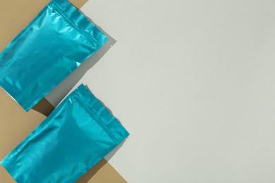 Photo of Zipper stand-up pouches on color background, flat lay. Mockup for design