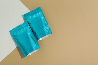 Photo of Zipper stand-up pouches on color background, flat lay. Mockup for design