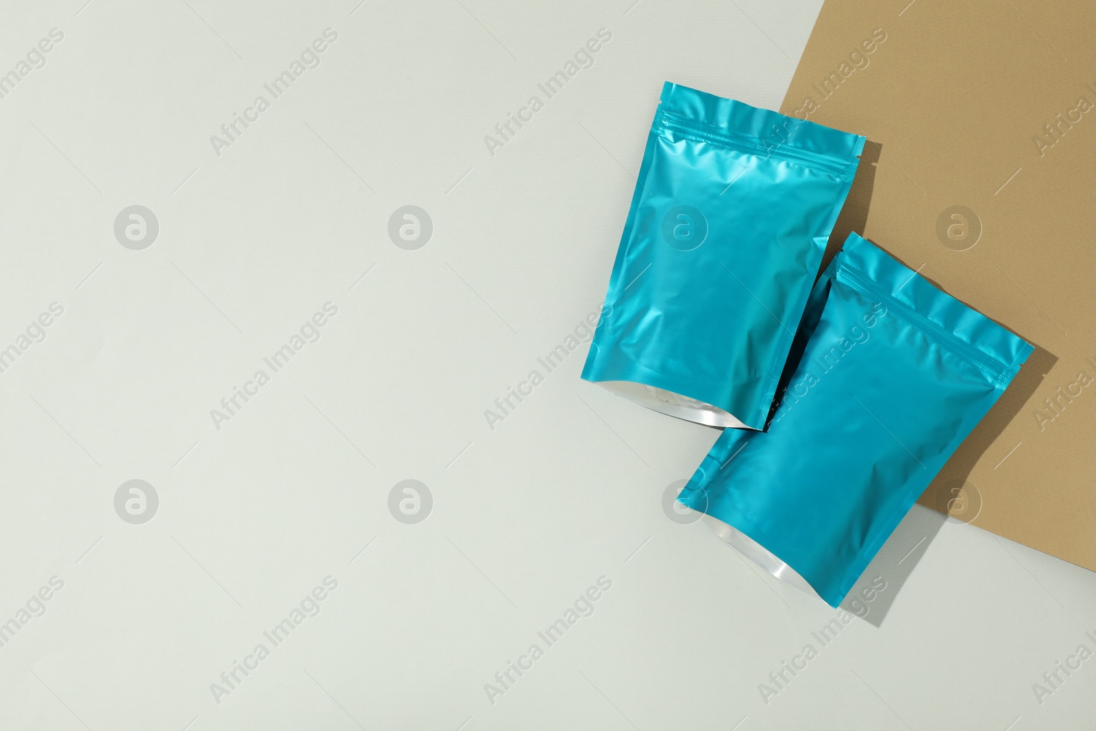 Photo of Zipper stand-up pouches on color background, flat lay. Mockup for design