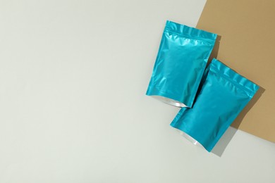 Photo of Zipper stand-up pouches on color background, flat lay. Mockup for design