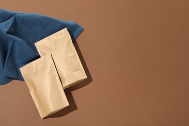 Photo of Zipper stand-up pouches on brown background, flat lay. Mockup for design