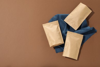 Photo of Zipper stand-up pouches on brown background, flat lay. Mockup for design