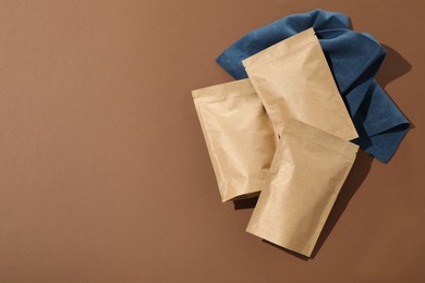 Photo of Zipper stand-up pouches on brown background, flat lay. Mockup for design