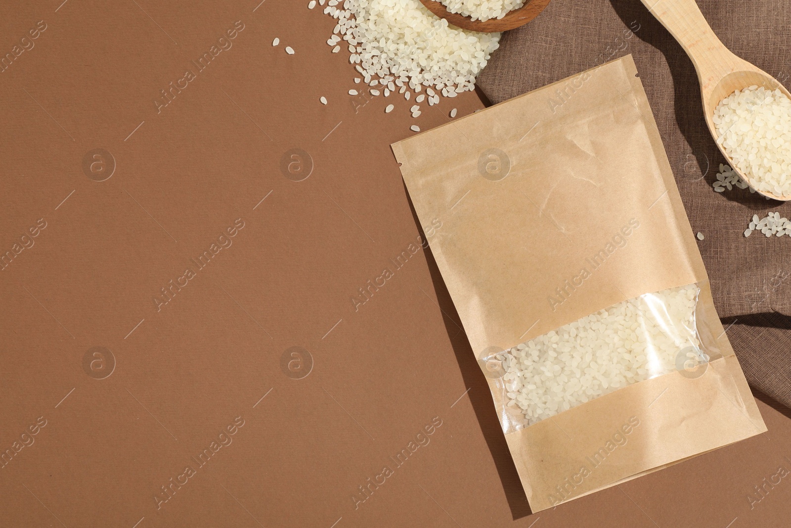 Zipper stand-up pouch and white rice on brown background, flat lay. Mockup for design Photo of Zipper stand-up pouch and white rice on brown background, flat lay. Mockup for design