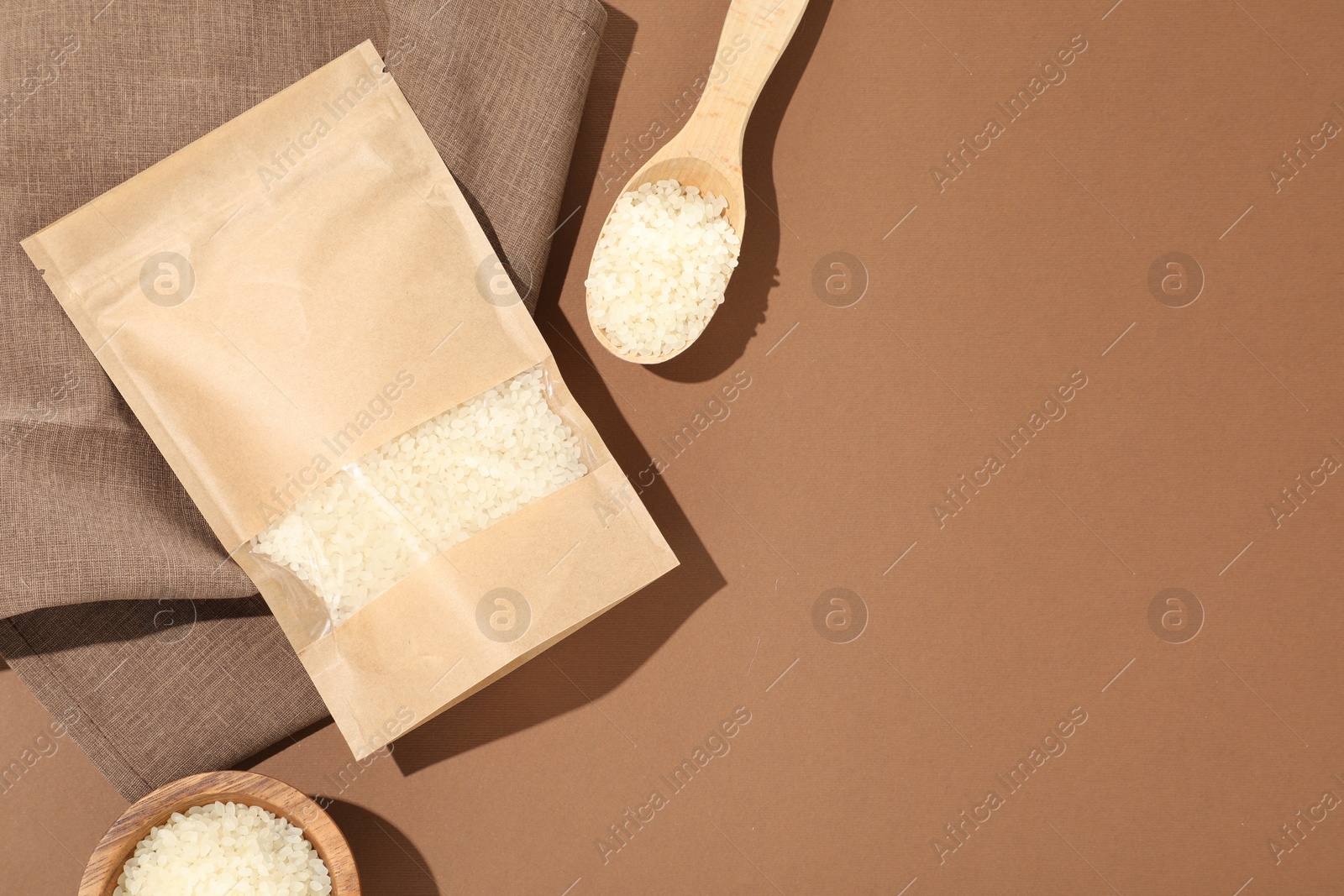 Zipper stand-up pouch and white rice on brown background, flat lay. Mockup for design Photo of Zipper stand-up pouch and white rice on brown background, flat lay. Mockup for design
