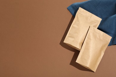 Photo of Zipper stand-up pouches on brown background, flat lay. Mockup for design