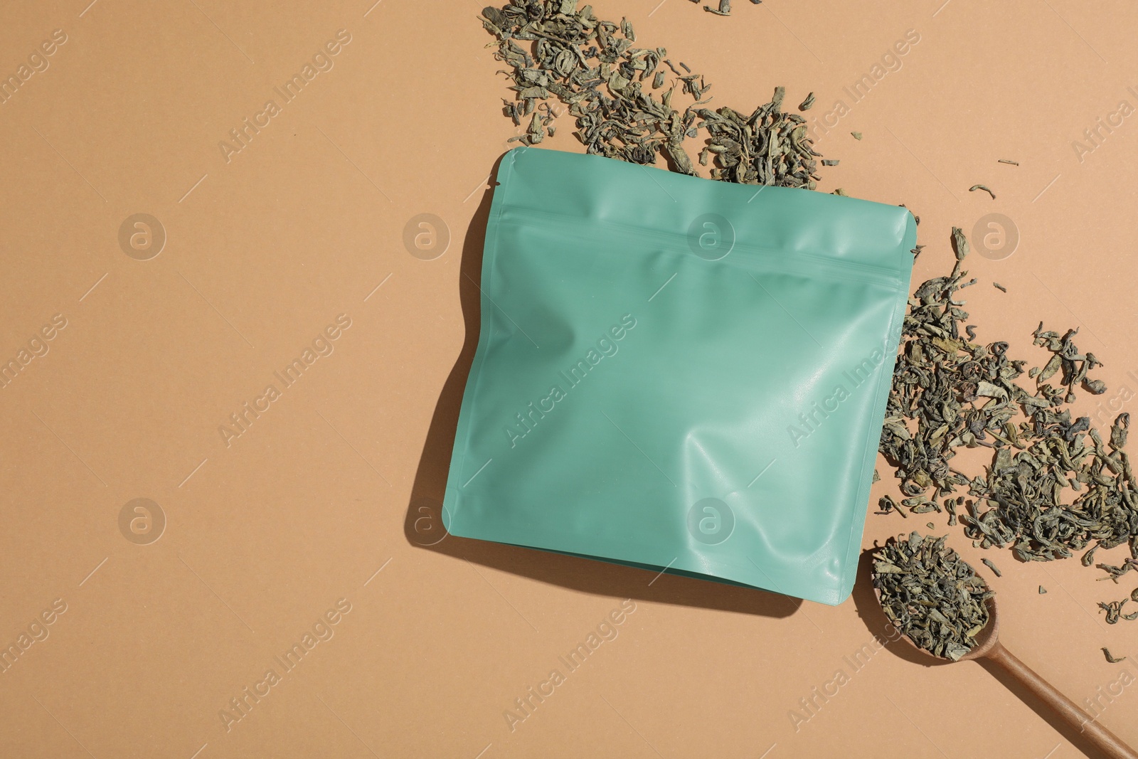 Zipper stand-up pouch and dry leaves on beige background, flat lay. Mockup for design Photo of Zipper stand-up pouch and dry leaves on beige background, flat lay. Mockup for design