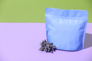 Photo of Zipper stand-up pouch and lavender flowers on color background, mockup for design