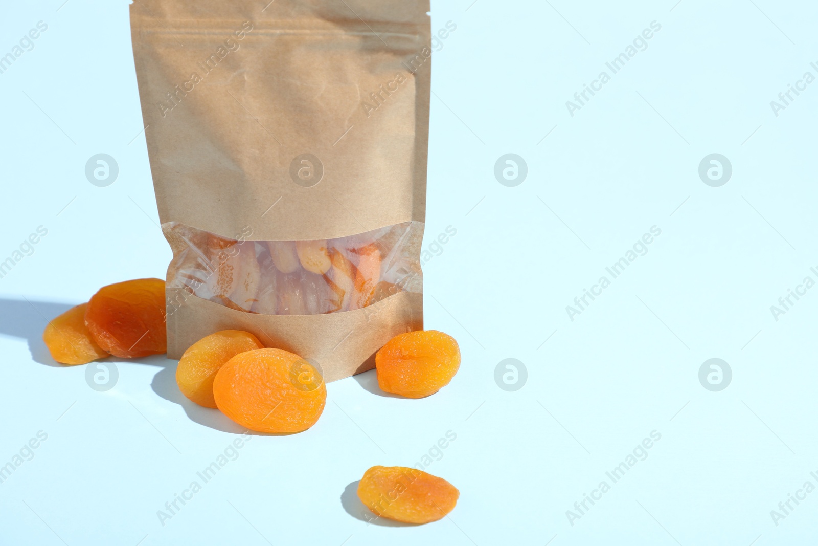 Zipper stand-up pouch with dried apricots on light blue background, closeup. Mockup for design Photo of Zipper stand-up pouch with dried apricots on light blue background, closeup. Mockup for design