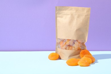 Photo of Zipper stand-up pouch with dried apricots on color background, mockup for design