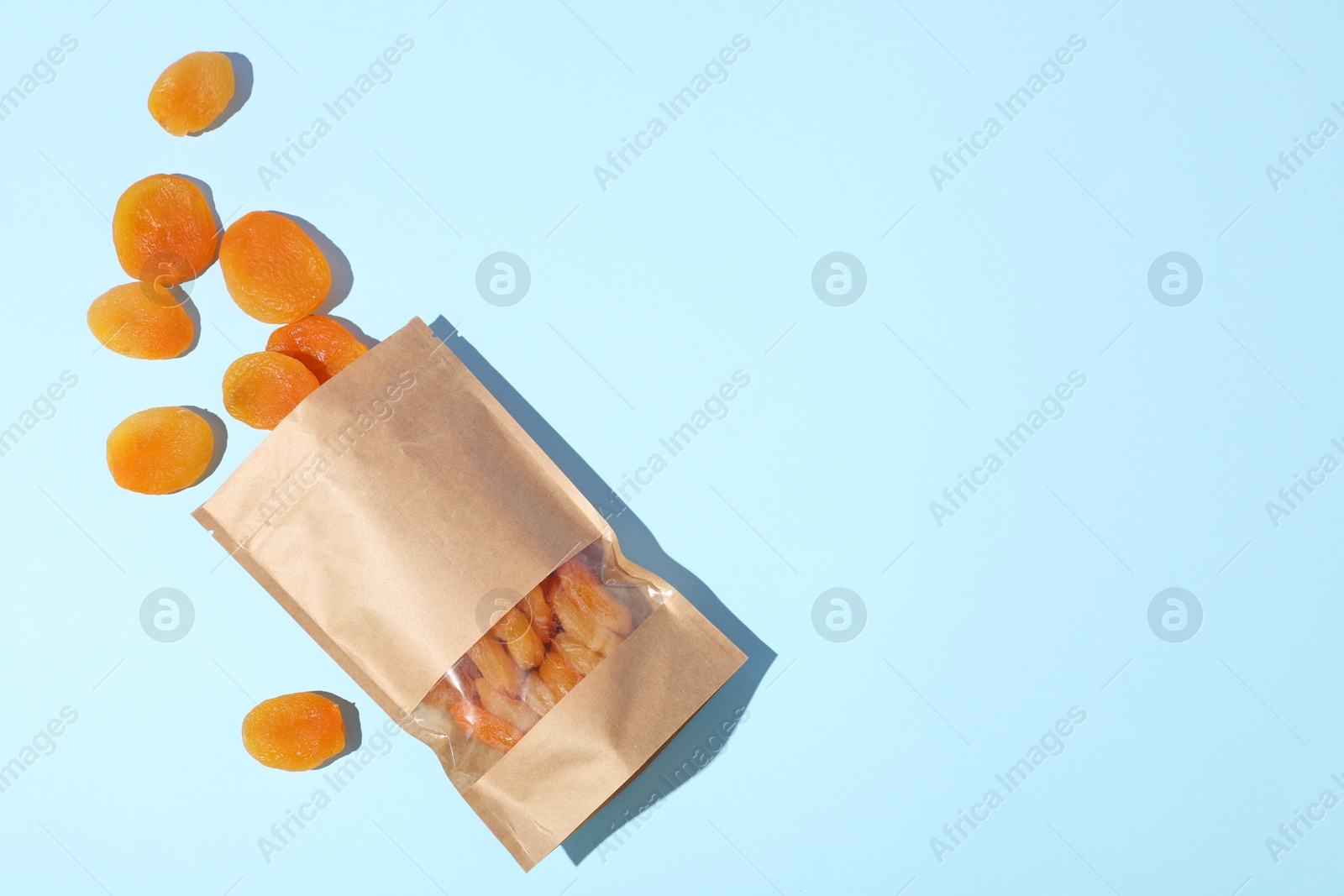 Zipper stand-up pouch with dried apricots on light blue background, flat lay. Mockup for design Photo of Zipper stand-up pouch with dried apricots on light blue background, flat lay. Mockup for design