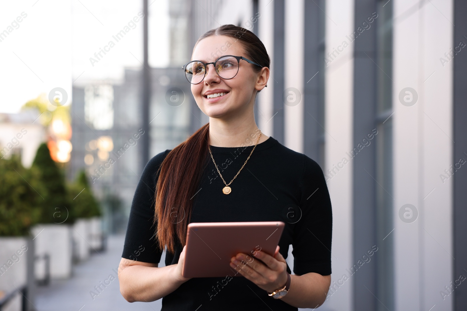 Successful businesswoman with tablet near office building Photo of Successful businesswoman with tablet near office building