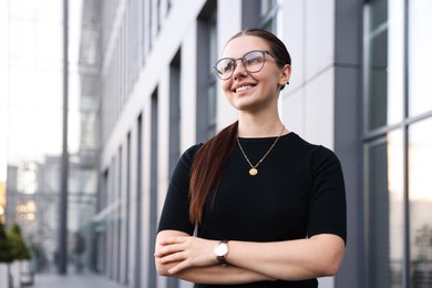 Photo of Portrait of successful businesswoman near office building. Space for text