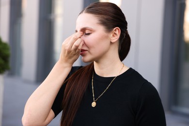 Photo of Portrait of tired businesswoman outside office building