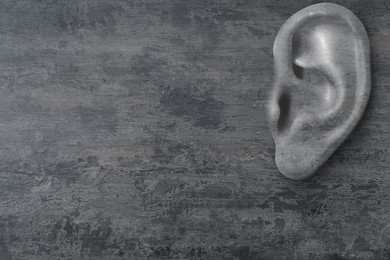 Image of Human ear in grey stone wall, space for text. Eavesdropping, concept that even walls have ears