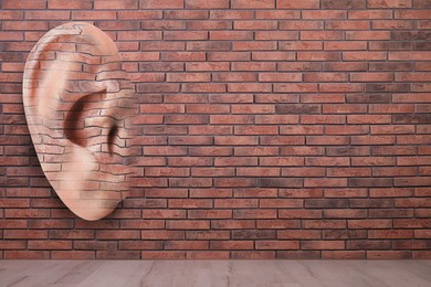 Image of Human ear in brick wall, space for text. Eavesdropping, concept that even walls have ears