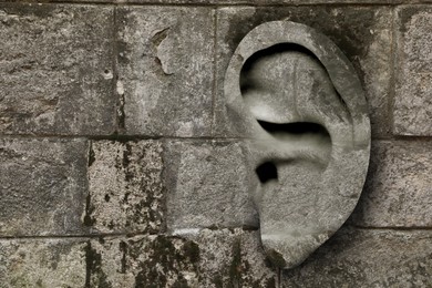 Image of Human ear in stone wall, space for text. Eavesdropping, concept that even walls have ears