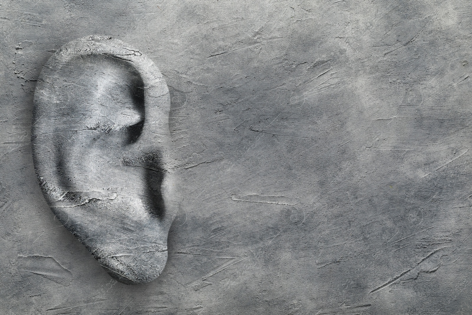 Image of Human ear in grey stone wall, space for text. Eavesdropping, concept that even walls have ears