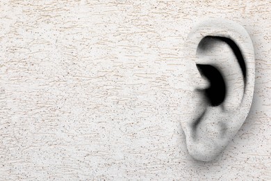 Image of Human ear in white plaster wall, space for text. Eavesdropping, concept that even walls have ears