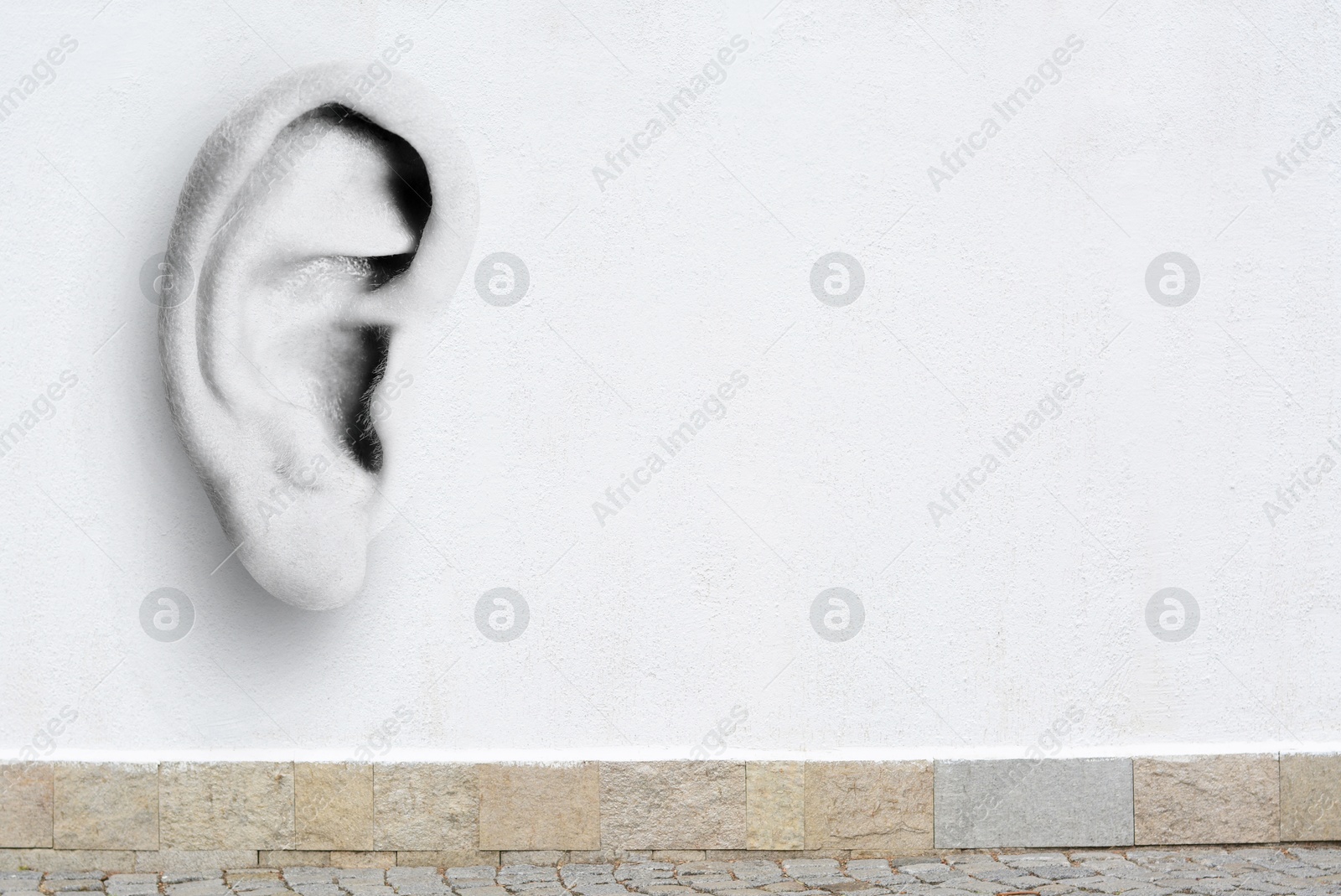 Human ear in white concrete wall, space for text. Eavesdropping, concept that even walls have ears Image of Human ear in white concrete wall, space for text. Eavesdropping, concept that even walls have ears
