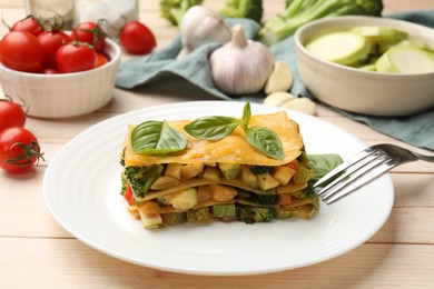Photo of Piece of tasty vegetarian lasagna served on white wooden table, closeup