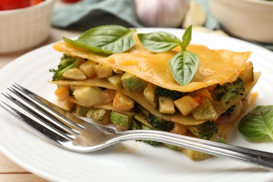 Photo of Piece of tasty vegetarian lasagna served on white wooden table, closeup