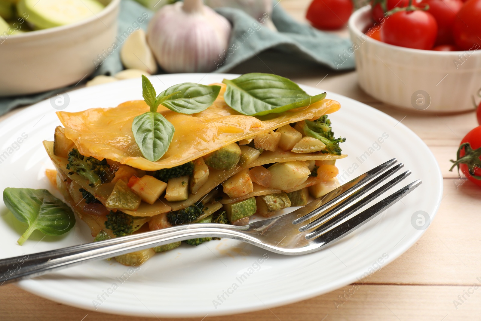 Piece of tasty vegetarian lasagna served on white wooden table, closeup Photo of Piece of tasty vegetarian lasagna served on white wooden table, closeup