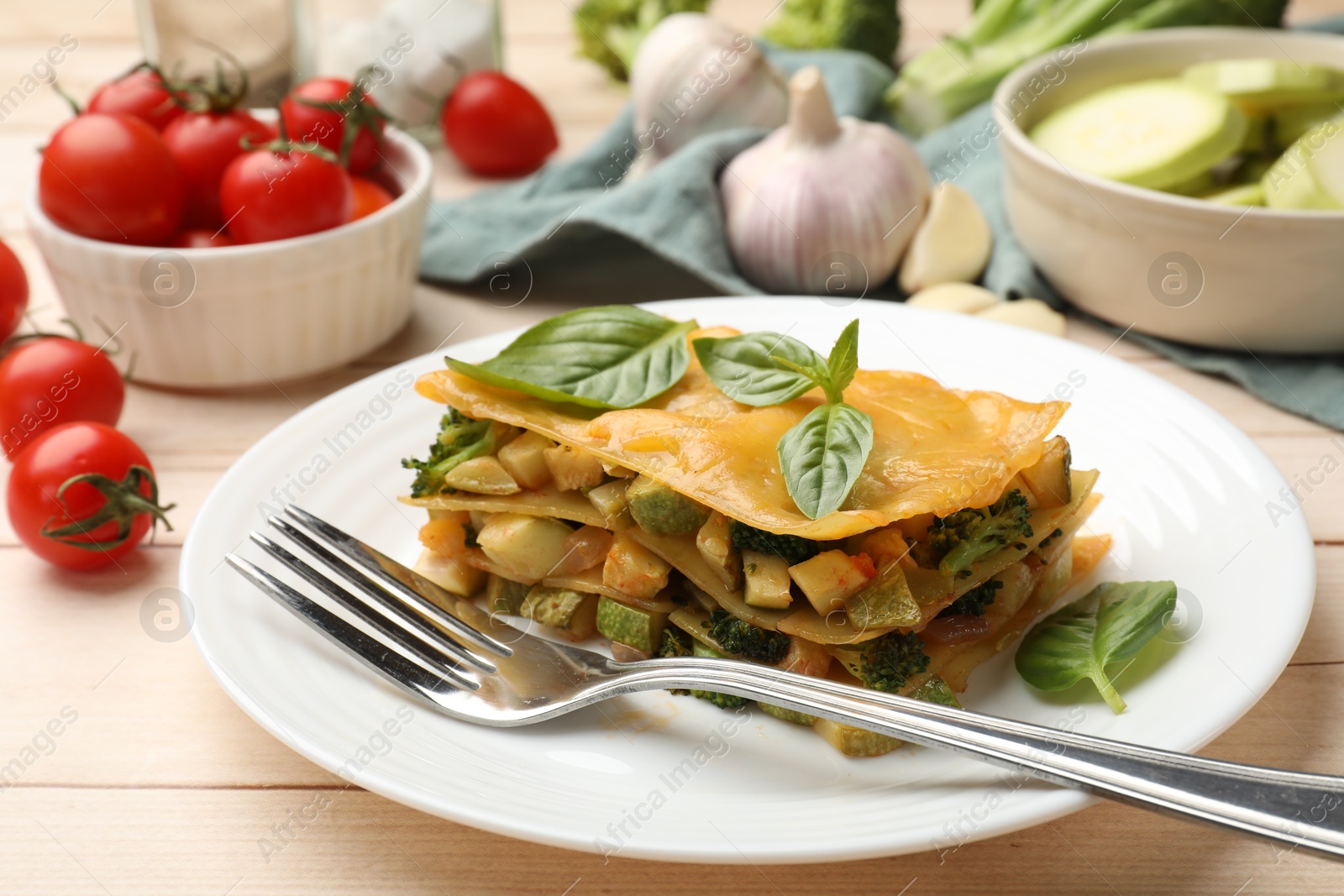 Piece of tasty vegetarian lasagna served on white wooden table, closeup Photo of Piece of tasty vegetarian lasagna served on white wooden table, closeup