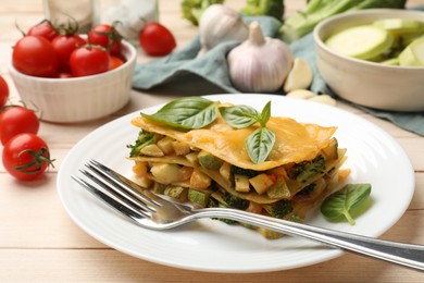 Photo of Piece of tasty vegetarian lasagna served on white wooden table, closeup
