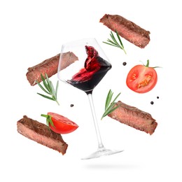 Image of Red wine in glass, grilled beef meat, tomatoes and spices falling on white background