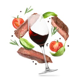 Image of Red wine in glass, grilled beef meat, tomatoes and spices falling on white background