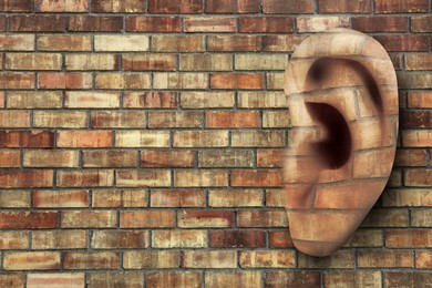 Image of Human ear in brick wall, space for text. Eavesdropping, concept that even walls have ears