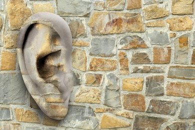 Image of Human ear in stone wall, space for text. Eavesdropping, concept that even walls have ears